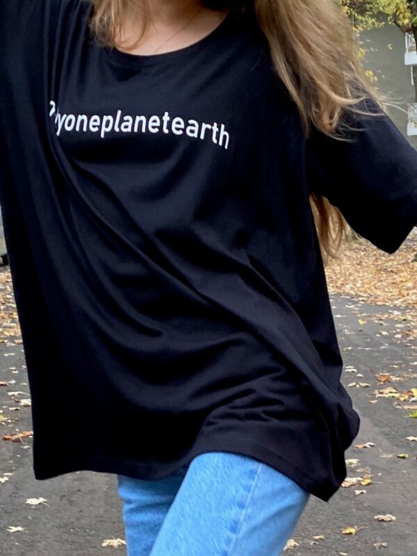 schwarzes big shirt oversized mit onlyoneplanetearth aufdruck in kombi mit jeans an junger Frau