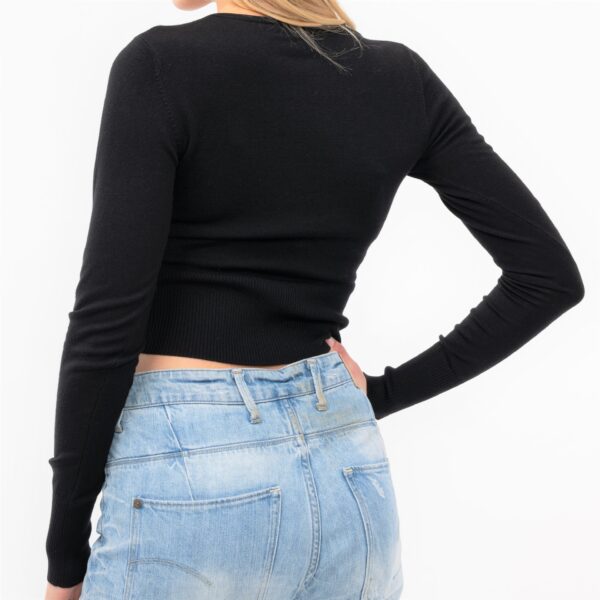 kurzer enger schwarzer Stretch Pullover mit verdrehtem Knoten am tiefen V- Ausschnitt und hohen Rippenbündchen von hinten